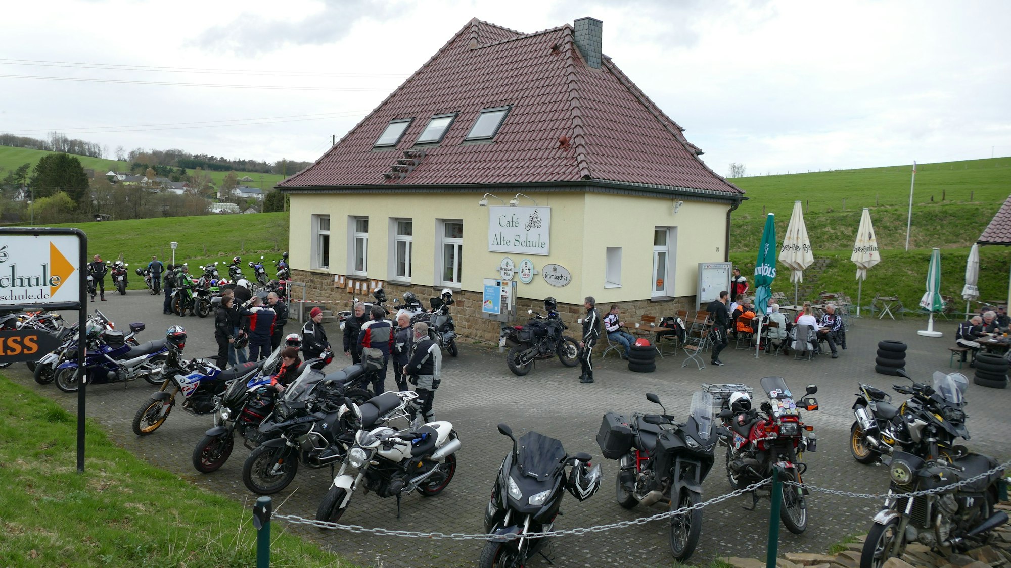 Viele Motorräder stehen auf dem Parkplatz vor einer Gaststätte.