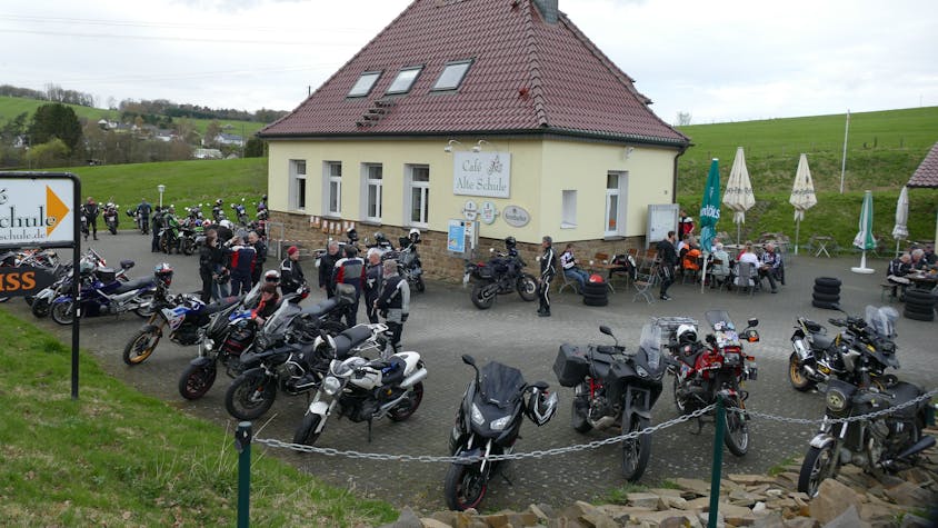 Viele Motorräder stehen auf dem Parkplatz vor einer Gaststätte.
