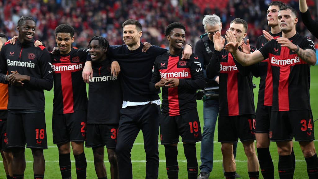 Xabi Alonso feiert nach dem Sieg von Bayer Leverkusen gegen die TSG Hoffenheim mit seinen Spielern Noah Mbamba, Amine Adli, Jeremie Frimpong, Nathan Tella, Florian Wirtz, Patrik Schick und Granit Xhaka.