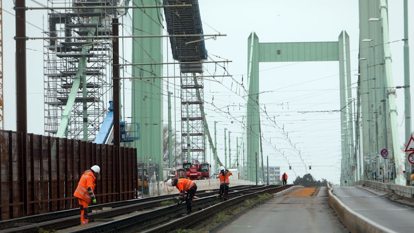 Zu sehen sind Bauarbeiter, die auf der Mülheimer Brücke in Köln arbeiten.