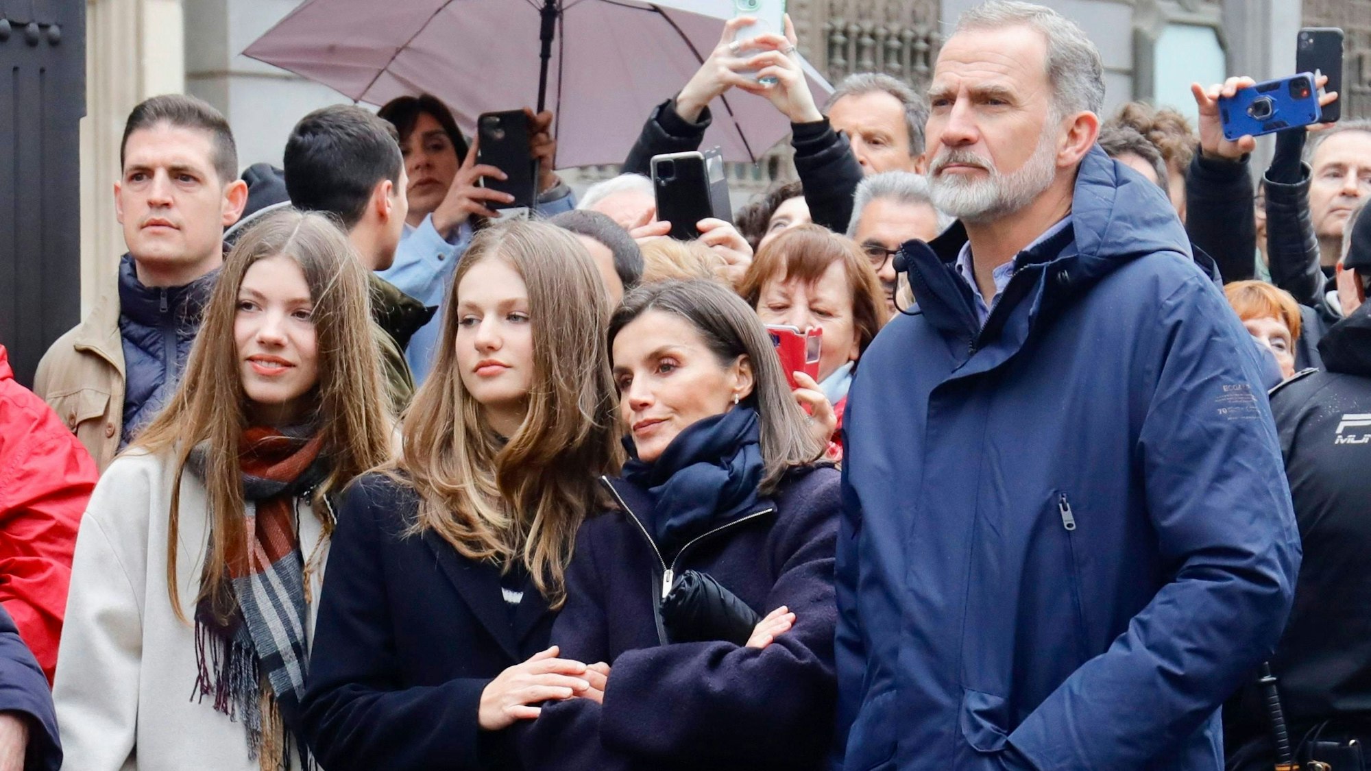 König Felipe (r) und Königin Letizia (m) standen mit ihren Töchtern Sofia und Leonor (l) wie alle anderen Schaulustigen am Straßenrand, um die Osterprozession zu beobachten.