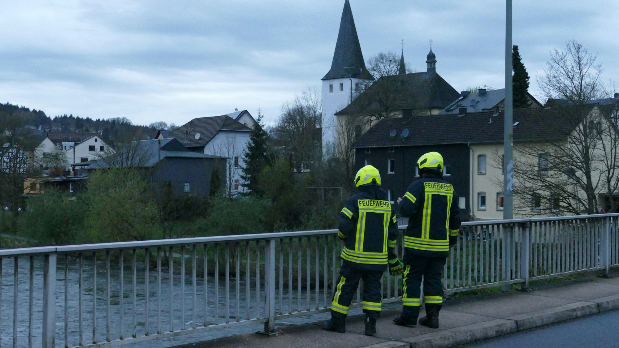 Feuerwehrleute stehen auf einer Brücke.