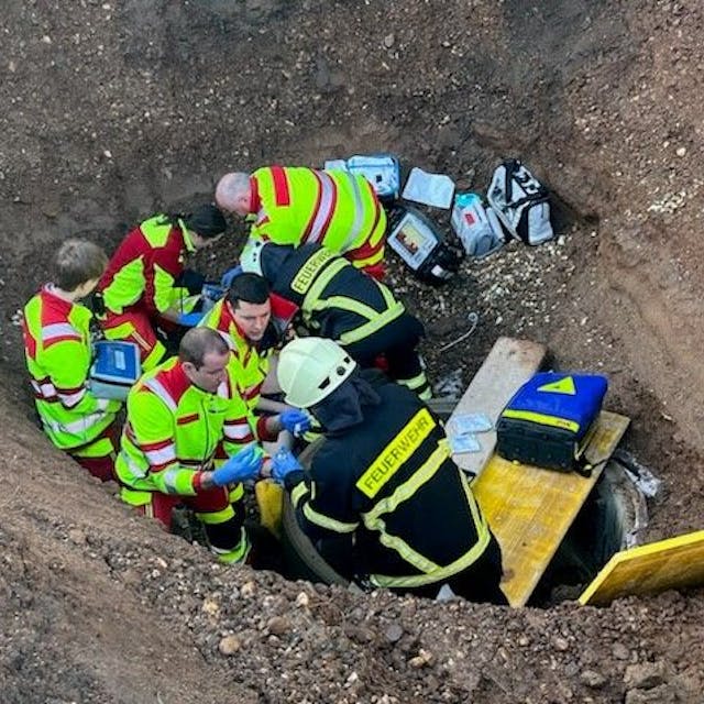 Das Bild zeigt Einsatzkräfte vom Rettungsdienst in einer Baugrube.