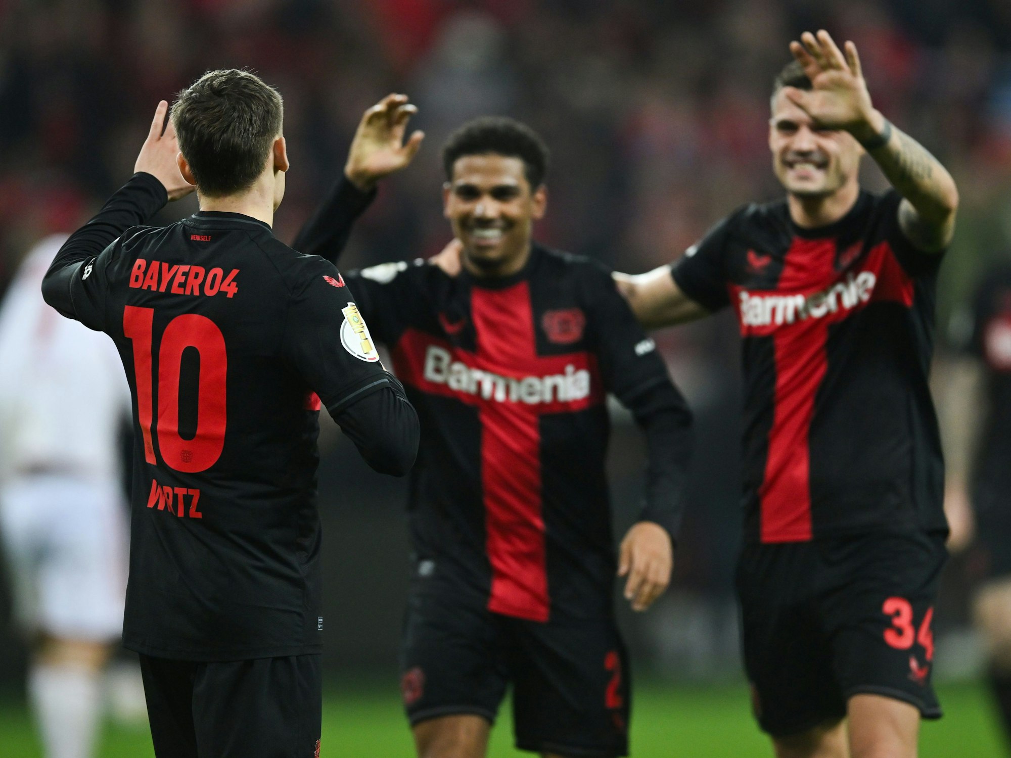 Leverkusens Florian Wirtz (l-r), Amine Adli und Granit Xhaka jubeln nach dem Tor zum 3:0.