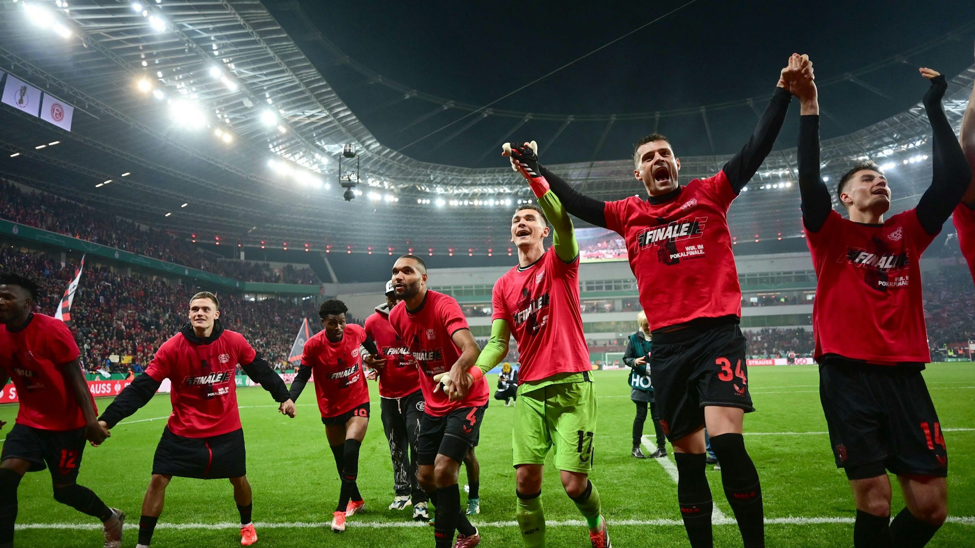 (LtoR) Bayer Leverkusen's Burkinabe defender #12 Edmond Tapsoba, Bayer Leverkusen's German midfielder #10 Florian Wirtz, Bayer Leverkusen's Nigerian midfielder #19 Nathan Tella, Bayer Leverkusen's German defender #04 Jonathan Tah, Leverkusen's Czech goalkeeper #17 Matej Kovar, Bayer Leverkusen's Swiss midfielder #34 Granit Xhaka and Bayer Leverkusen's Czech forward #14 Patrik Schick celebrate their team's 4-0 win after the German Cup (DFB-Pokal) semi-final football match between Bayer 04 Leverkusen and Fortuna Duesseldorf in Leverkusen, western Germany on April 3, 2024. (Photo by INA FASSBENDER / AFP) / DFB REGULATIONS PROHIBIT ANY USE OF PHOTOGRAPHS AS IMAGE SEQUENCES AND QUASI-VIDEO.