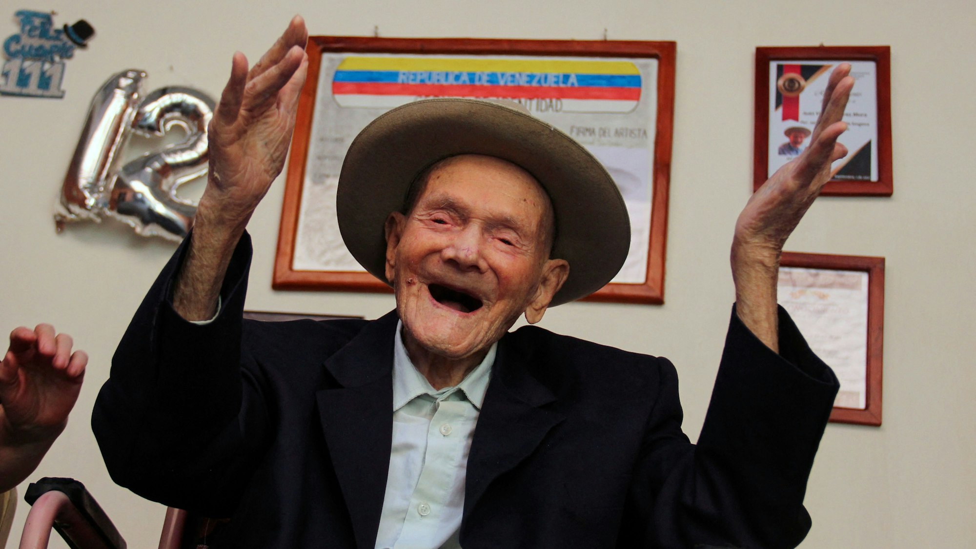 Ein Bild des Venezolaners Juan Vicente Pérez Mora, aufgenommen im Januar 2022, als er 112 Jahre alt war. Er lacht und hält die Hände in die Höhe