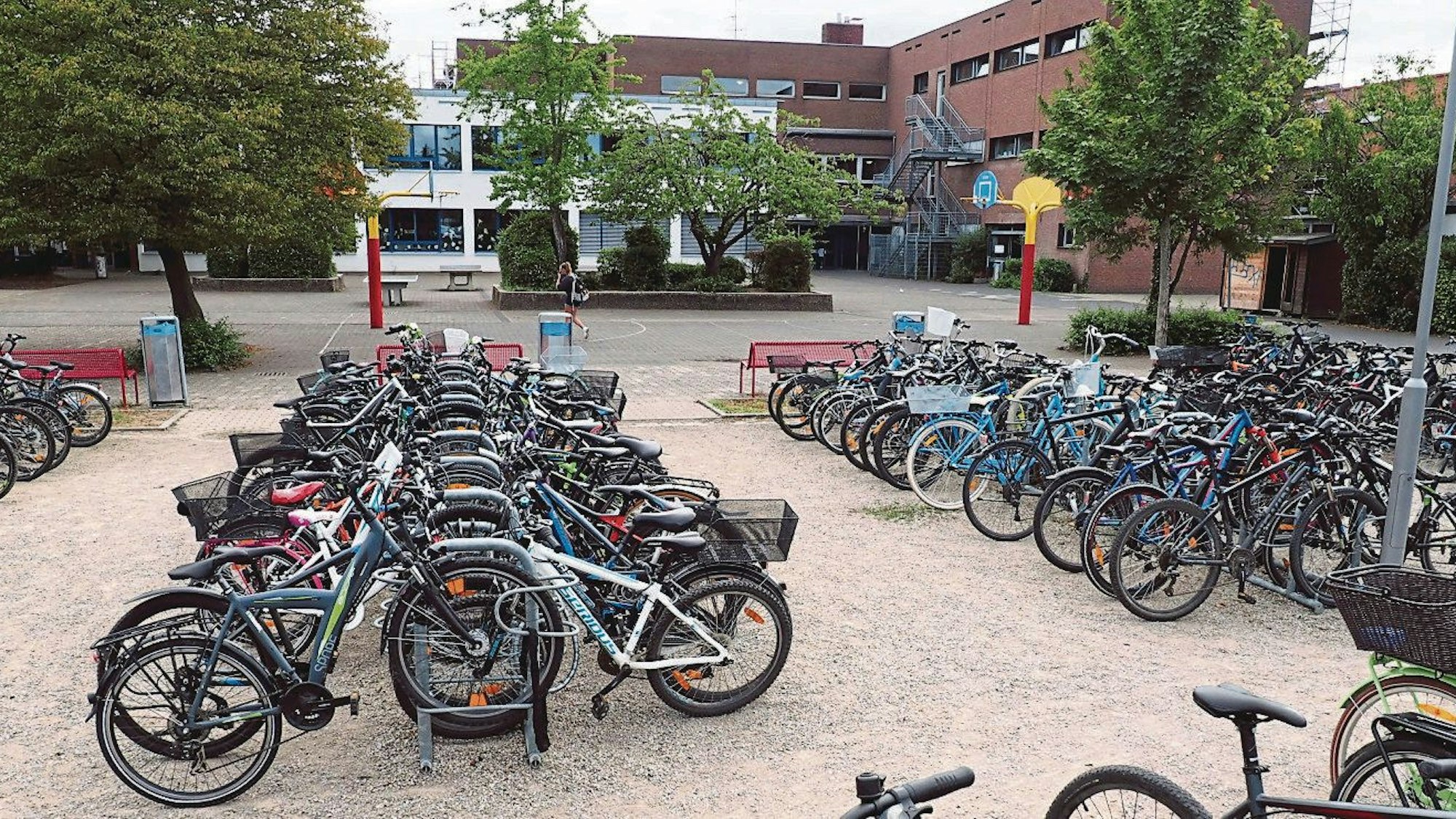 Im Hintergrund zwei Gebäude der Marion-Dönhoff-Realschule, im Vordergrund viele Fahrräder.
