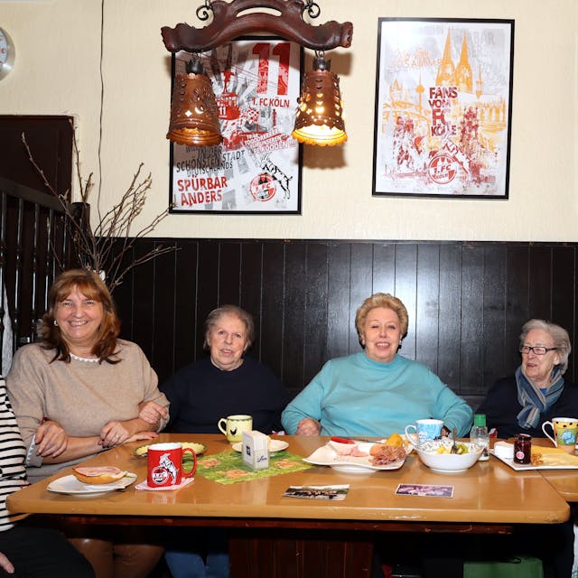 Sechs Seniorinnen, die an einem Tisch mit Frühstücksgedeck in einer Kölner Kneipe sitzen