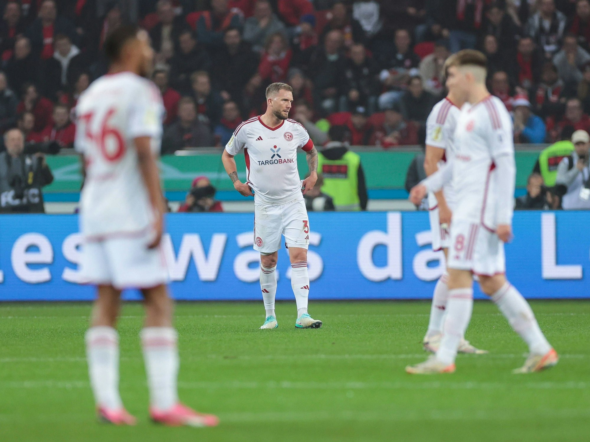 Die Spieler von Fortuna Düsseldorf stehen beim Spiel in Leverkusen enttäuscht auf dem Platz.