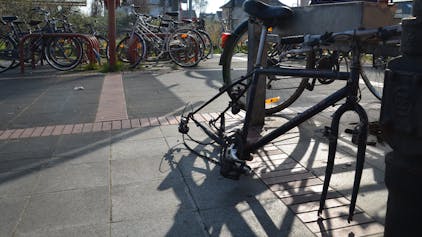 Kaputtes Fahrrad an einem öffentlichen Fahrradständer