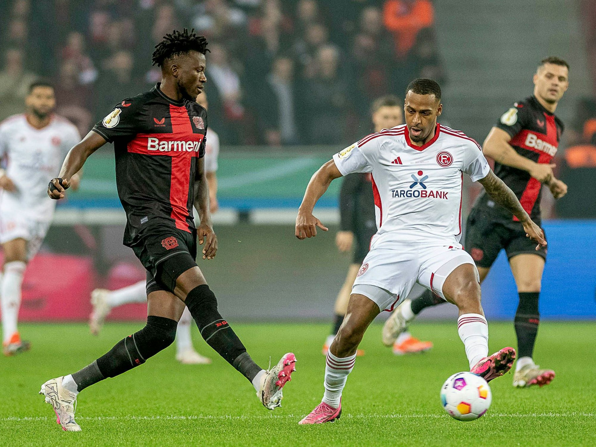 Bayer Leverkusens Edmond Tapsoba und Fortuna Düsseldorfs Marlon Mustapha kämpfen um den Ball.