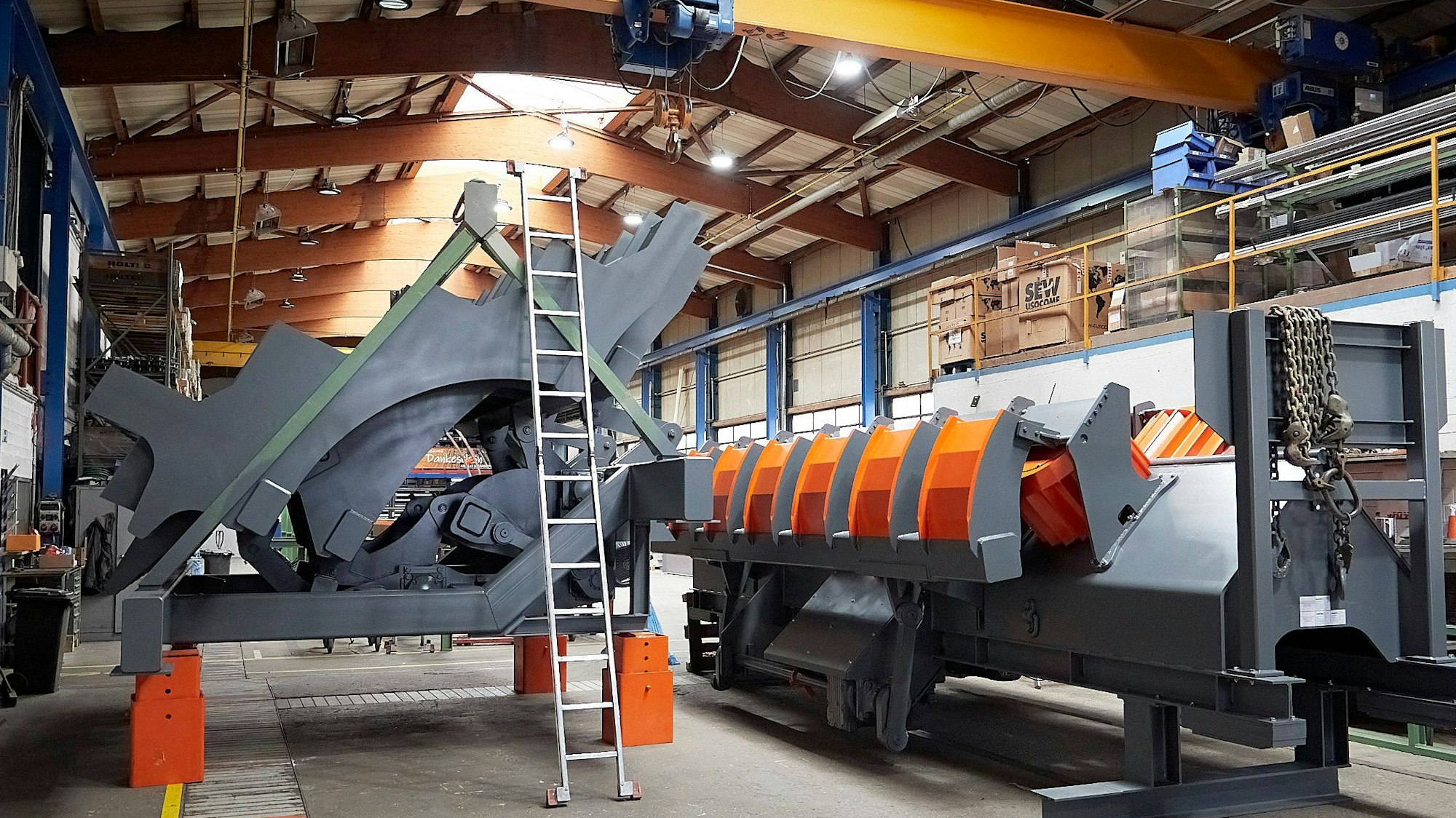 Zwei Tonnenschwere Maschinen für die Rundholzbearbeitung stehen in einer Produktionshalle der Firma Holtec in Blumenthal.