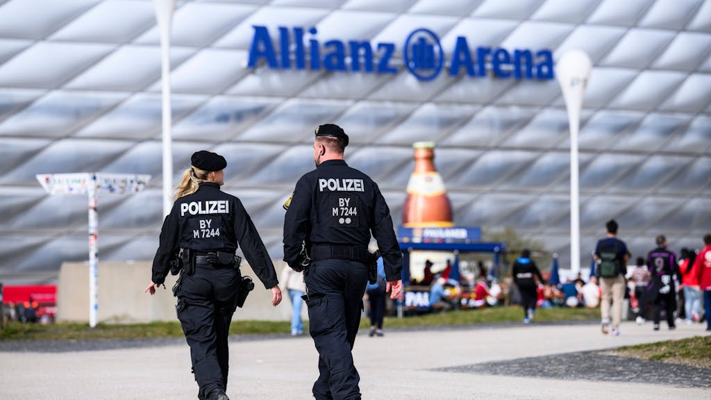 Eine Polizistin und ein Polizist laufen im März 2024 vor der Allianz-Arena in München: Die Polizei in Bayern sorgt aktuell mit einem hosenlosen Video für reichlich Wirbel.