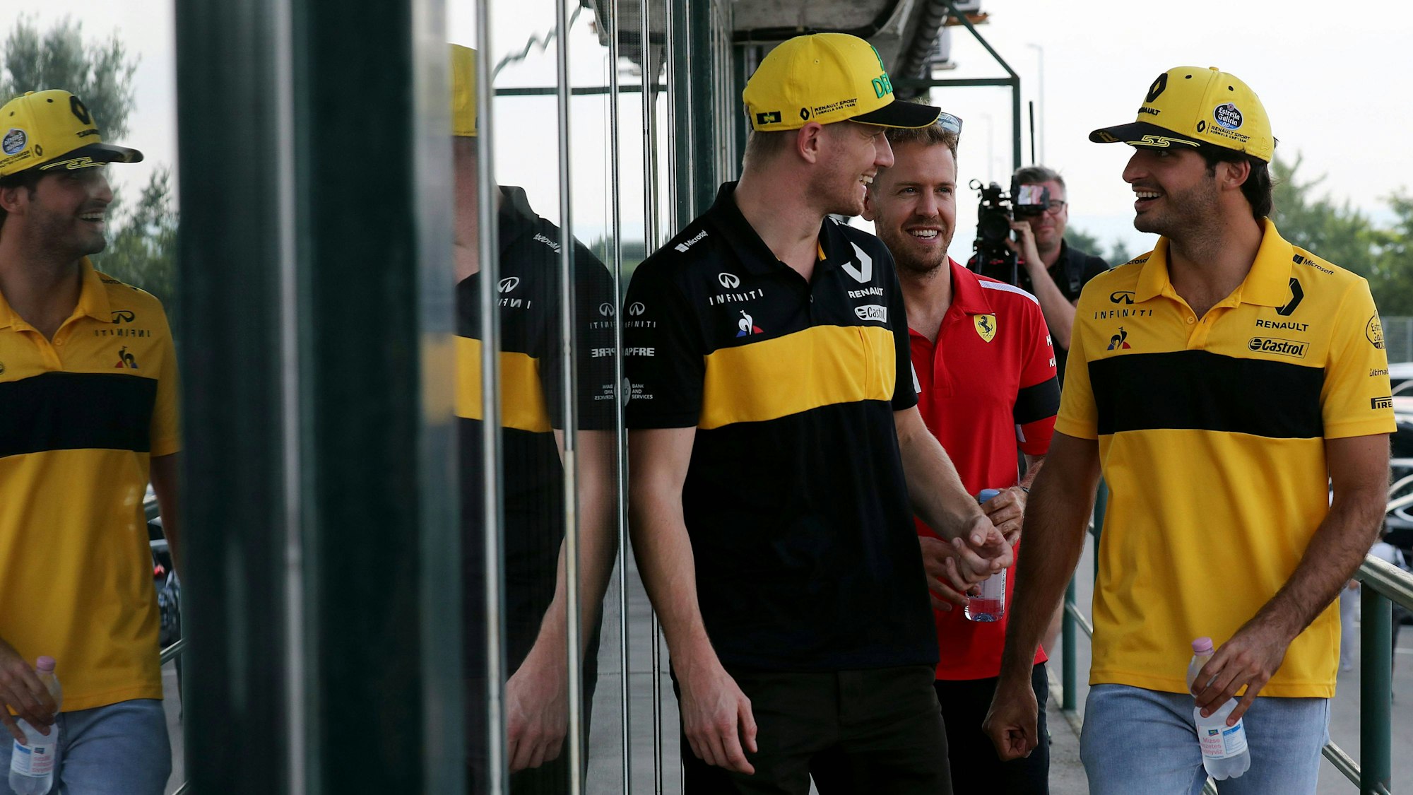 Nico Hülkenberg (l.) und Carlos Sainz sprechen im Fahrerlager. Auch der damalige Ferrari-Star Sebastian Vettel (M.) hat Spaß.