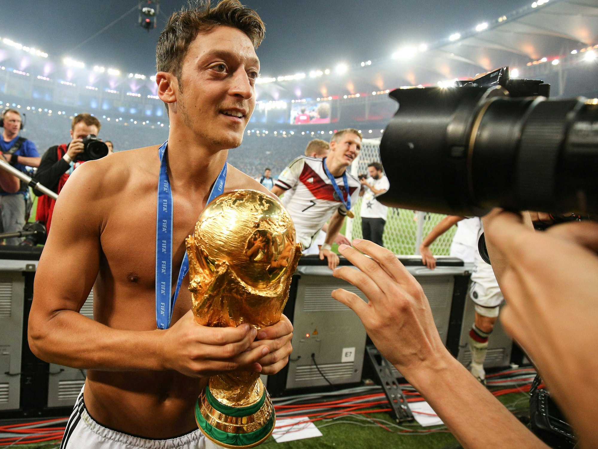 Mesut Özil feiert oberkörperfrei und mit dem WM-Pokal im Arm den Weltmeistertitel mit Deutschland.