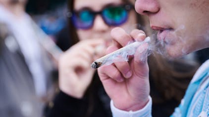Zwei Menschen rauchen einen Joint bei einer Demonstration in Berlin.&nbsp;