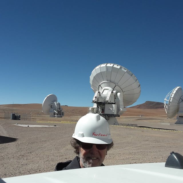 Ferdi Patt auf der Hochebene Chajnantorin in Chile auf 5000 Meter. Im Hintergrund einige der ALMA-Antennen.