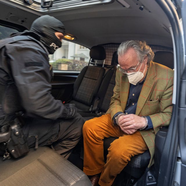 Bei einer Razzia gegen sogenannte „Reichsbürger“ sitzt ein vermummter Polizist, nach der Durchsuchung eines Hauses, mit dem festgenommenen Heinrich XIII Prinz Reuß (r) in einem Polizeifahrzeug.&nbsp;