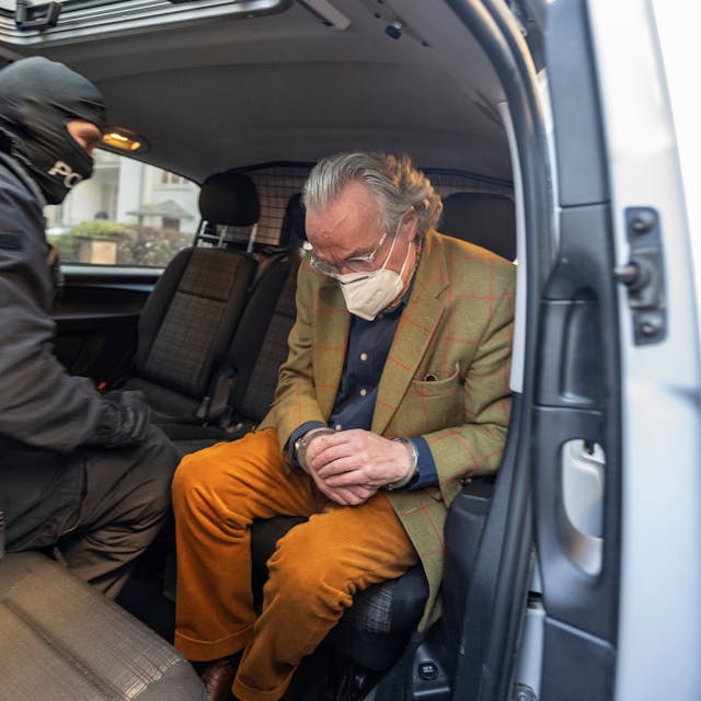 Bei einer Razzia gegen sogenannte „Reichsbürger“ sitzt ein vermummter Polizist, nach der Durchsuchung eines Hauses, mit dem festgenommenen Heinrich XIII Prinz Reuß (r) in einem Polizeifahrzeug.&nbsp;