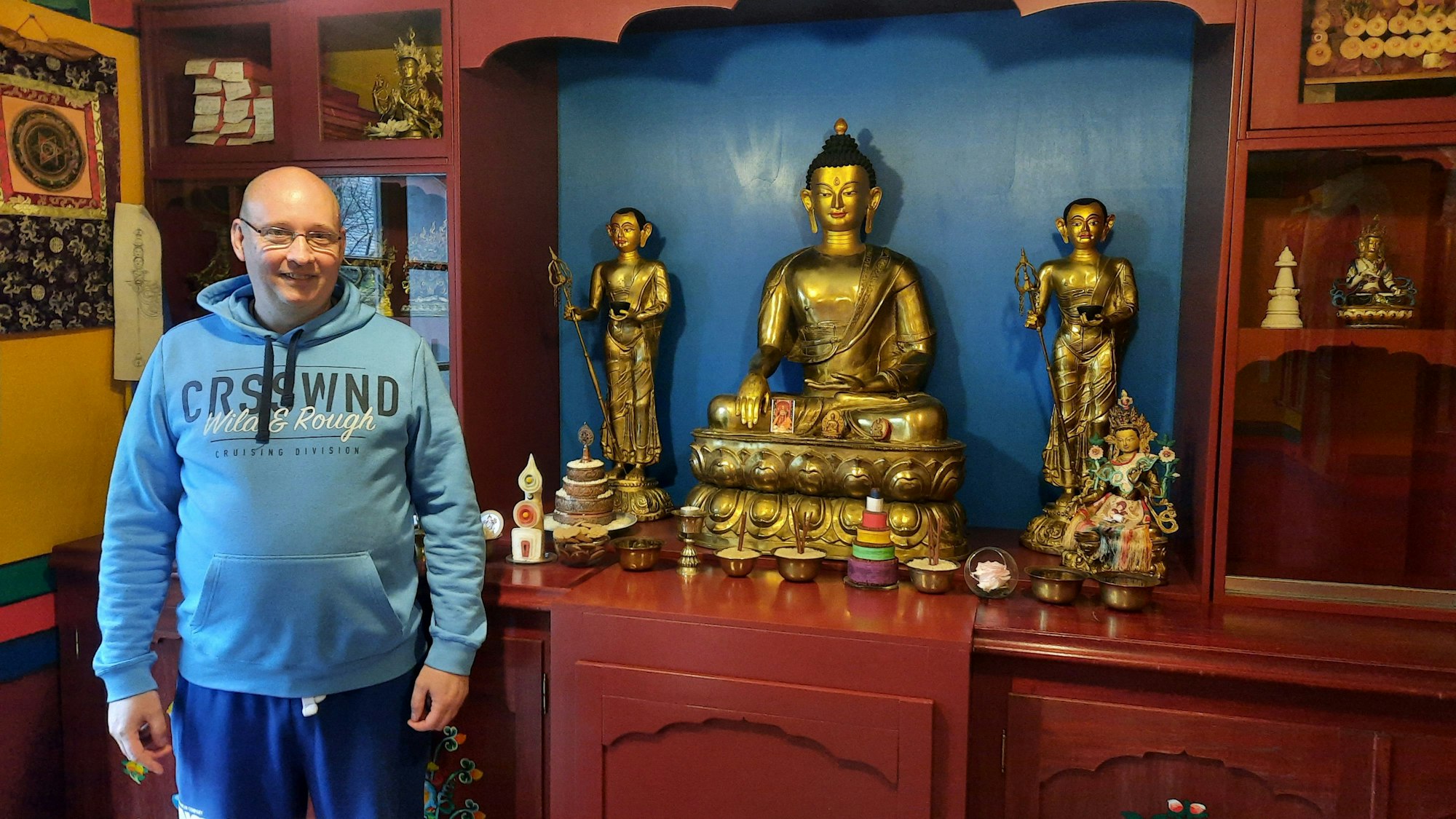 Ein Mann steht vor buddhistischen Statuen