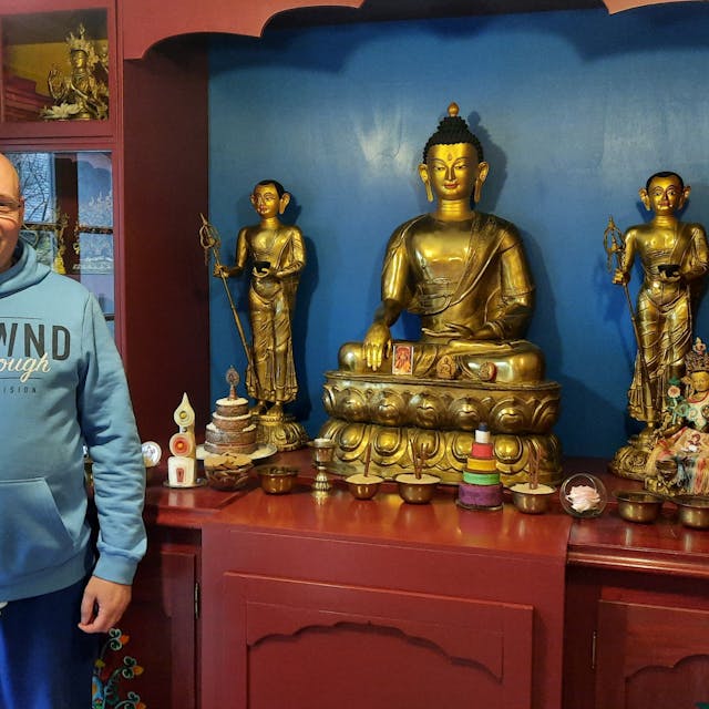 Ein Mann steht vor buddhistischen Statuen&nbsp;