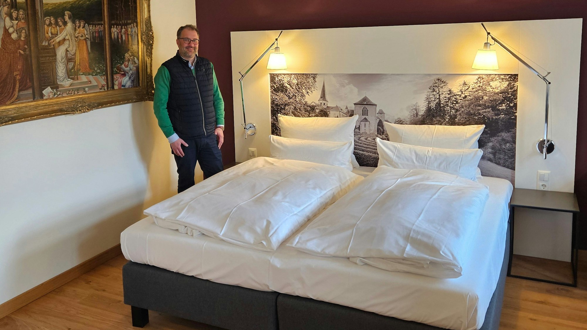 Der Leiter der Gästehäuser, Christoph Böhnke, steht neben einem Bett in einem der neuen Zimmer.