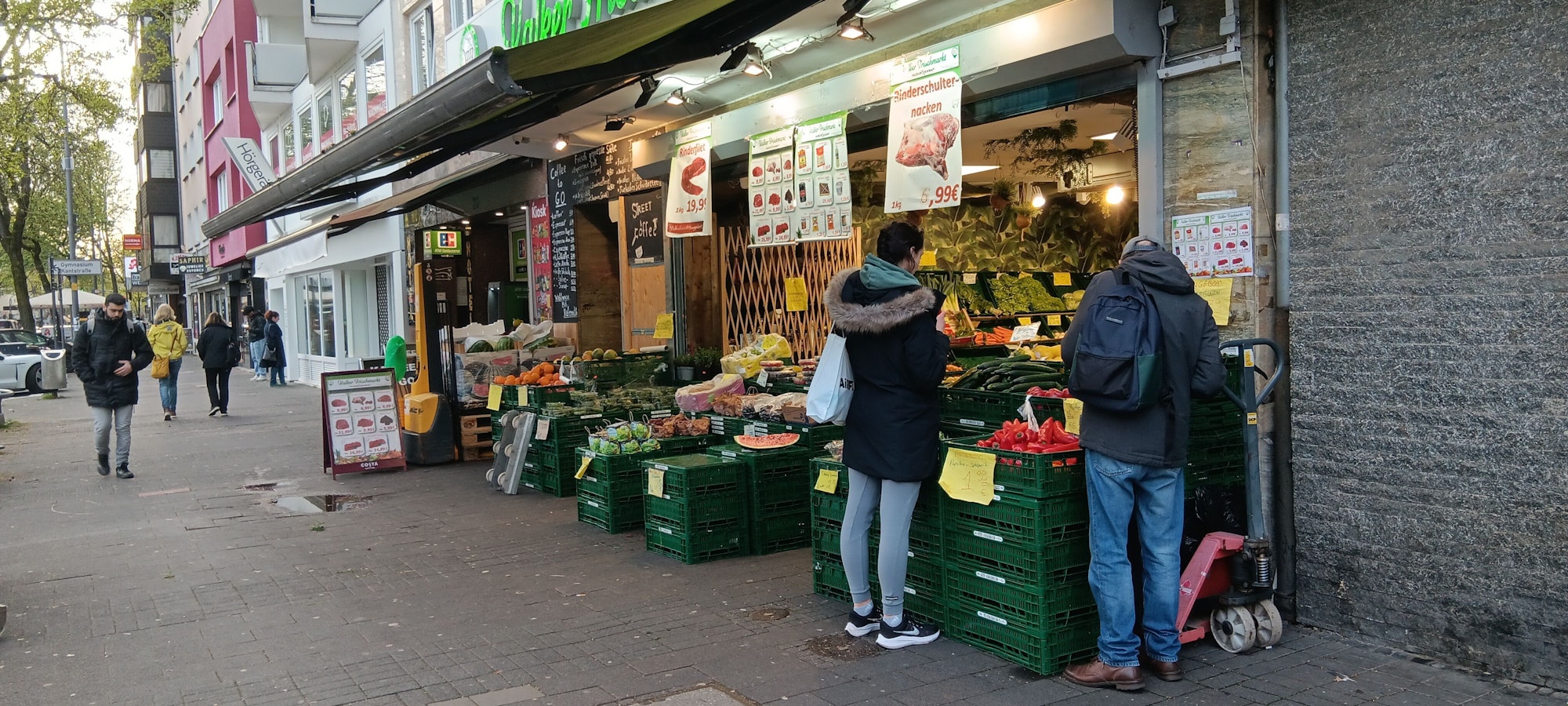 Ein Mann und eine Frau stehen vor einem Gemüsegeschäft.