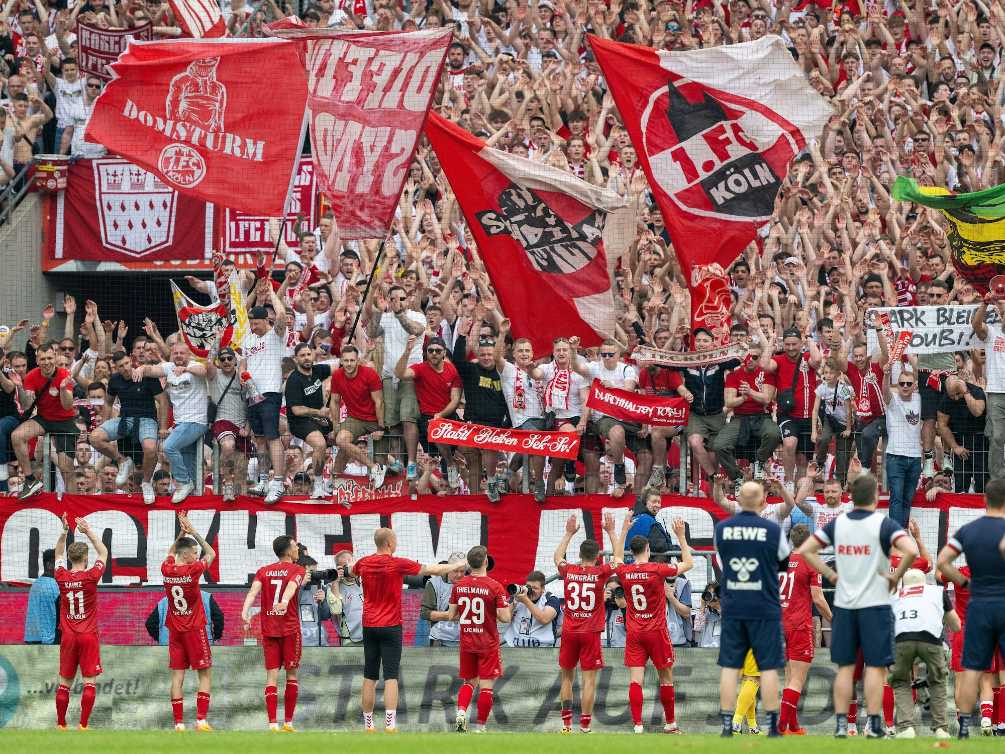 Die Spieler des 1. FC Köln jubeln mit ihren Fans.
