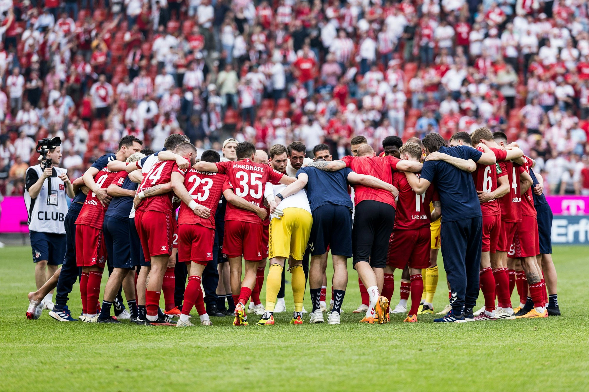 Spieler und Trainer des 1. FC Köln bilden einen Kreis nach dem Spiel.