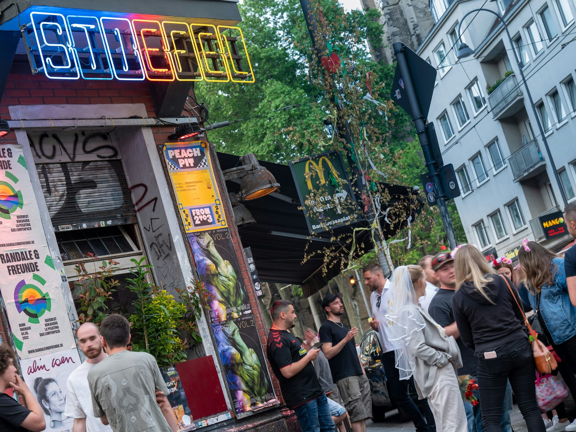 Partygäste stehen vor dem Eingang der Kölner Kneipe Stiefel auf der Zülpicher Straße.