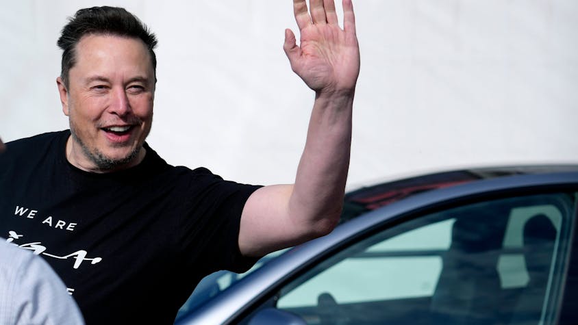 Elon Musk, Tesla-Chef, winkt in eine Kamera.