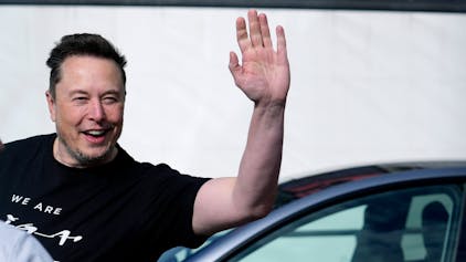 Elon Musk, Tesla-Chef, winkt in eine Kamera.