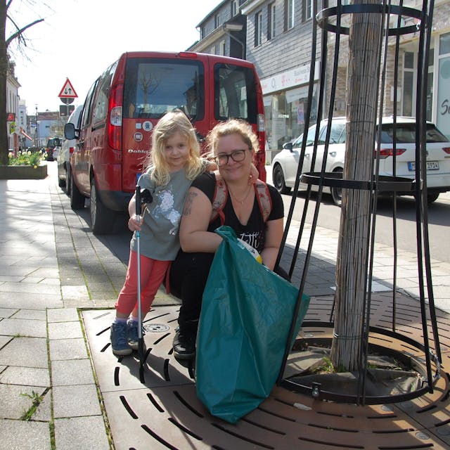 Die vierjährige Romina und ihre Mutter säubern die Hauptstraße in Burscheid.