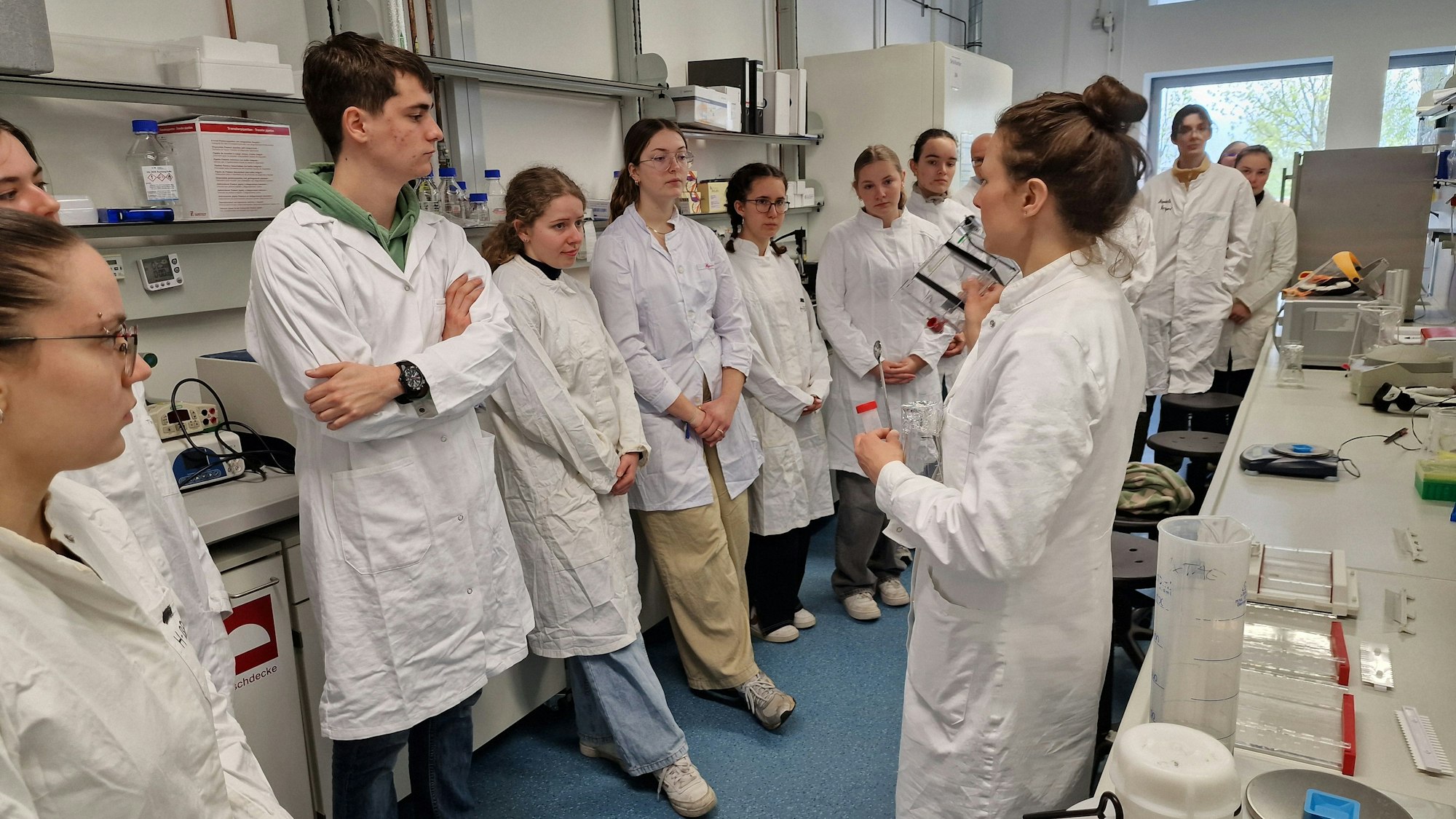 Die Wissenschaftliche Mitarbeiterin Dagmar Kochler (r.) erklärt den Schnupperstudenten die nächsten Schritte der Laborarbeit 