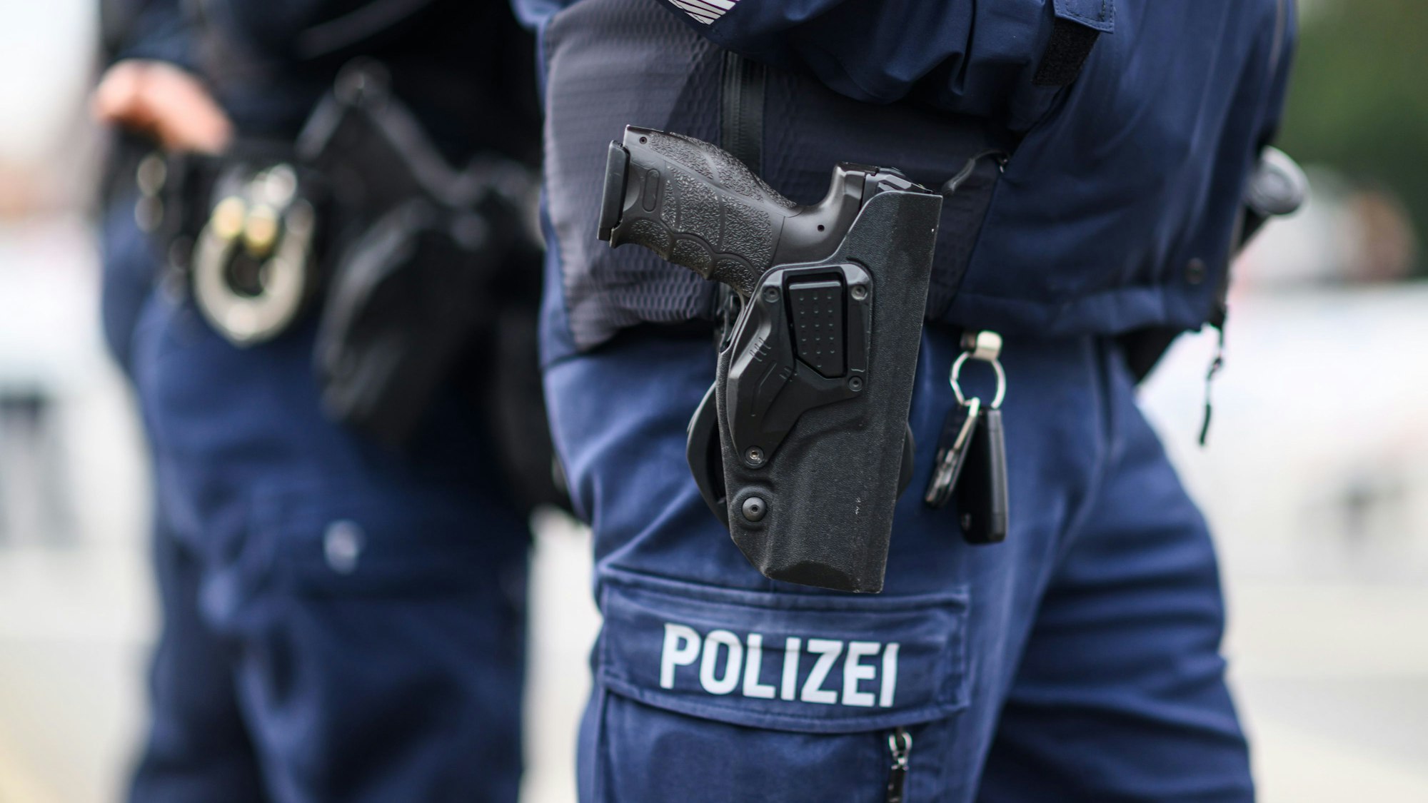 Das Bild zeigt zwei Polizeibeamte mit Dienstwaffe im Holster.