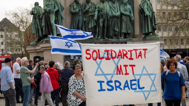 Menschen halten ein Banner hoch mit der Aufschrift „Solidarität mit Israel“.