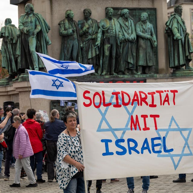 Menschen halten ein Banner hoch mit der Aufschrift „Solidarität mit Israel“.