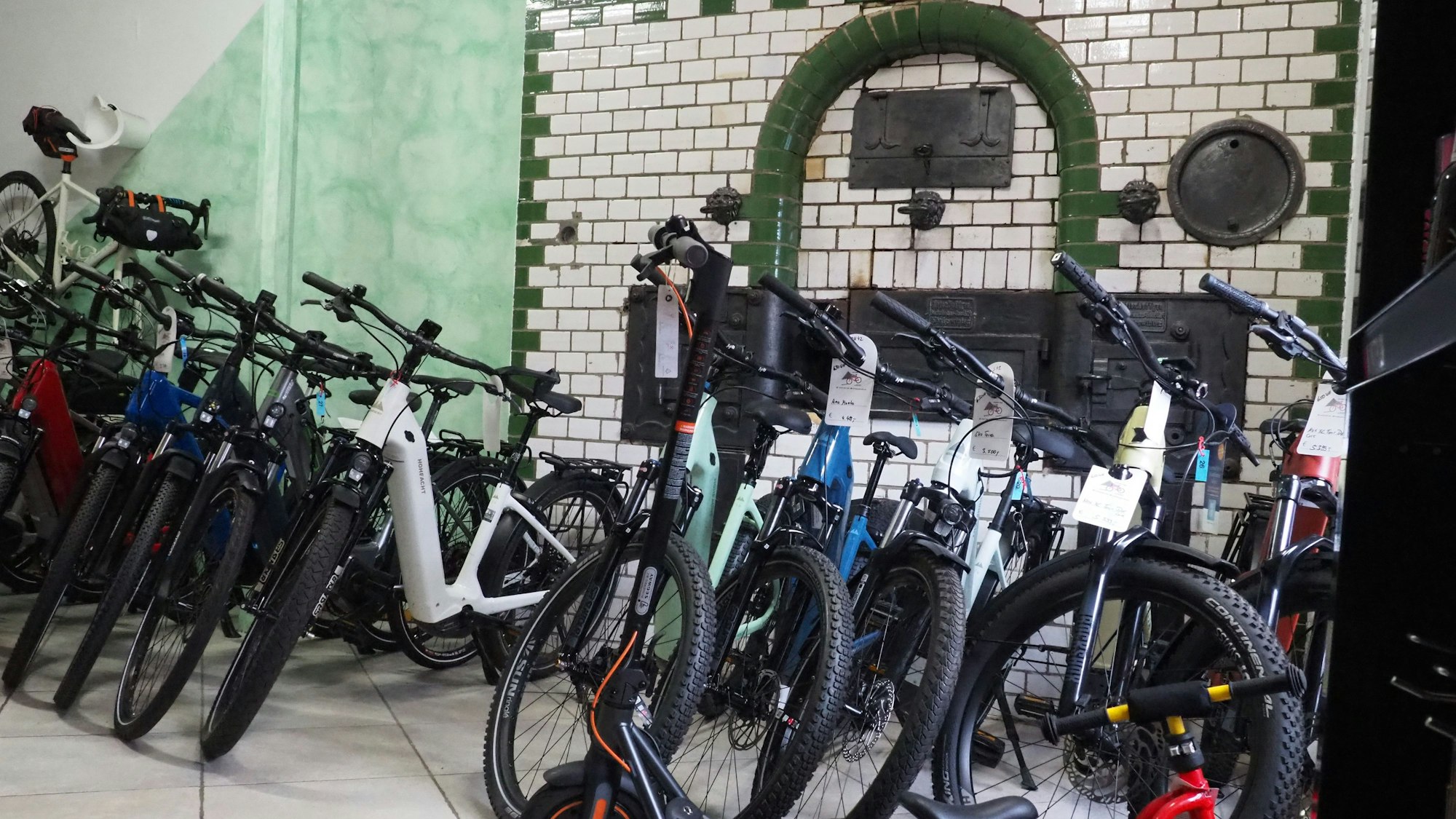 Zahlreiche neue Fahrräder stehen vor einem historischen Backofen: Das Fahrradgeschäft war in einer ehemaligen Bäckerei.