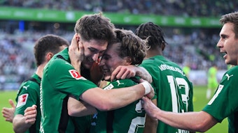 Spieler von Borussia Mönchengladbach freuen sich über einen Treffer und umarmen sich.