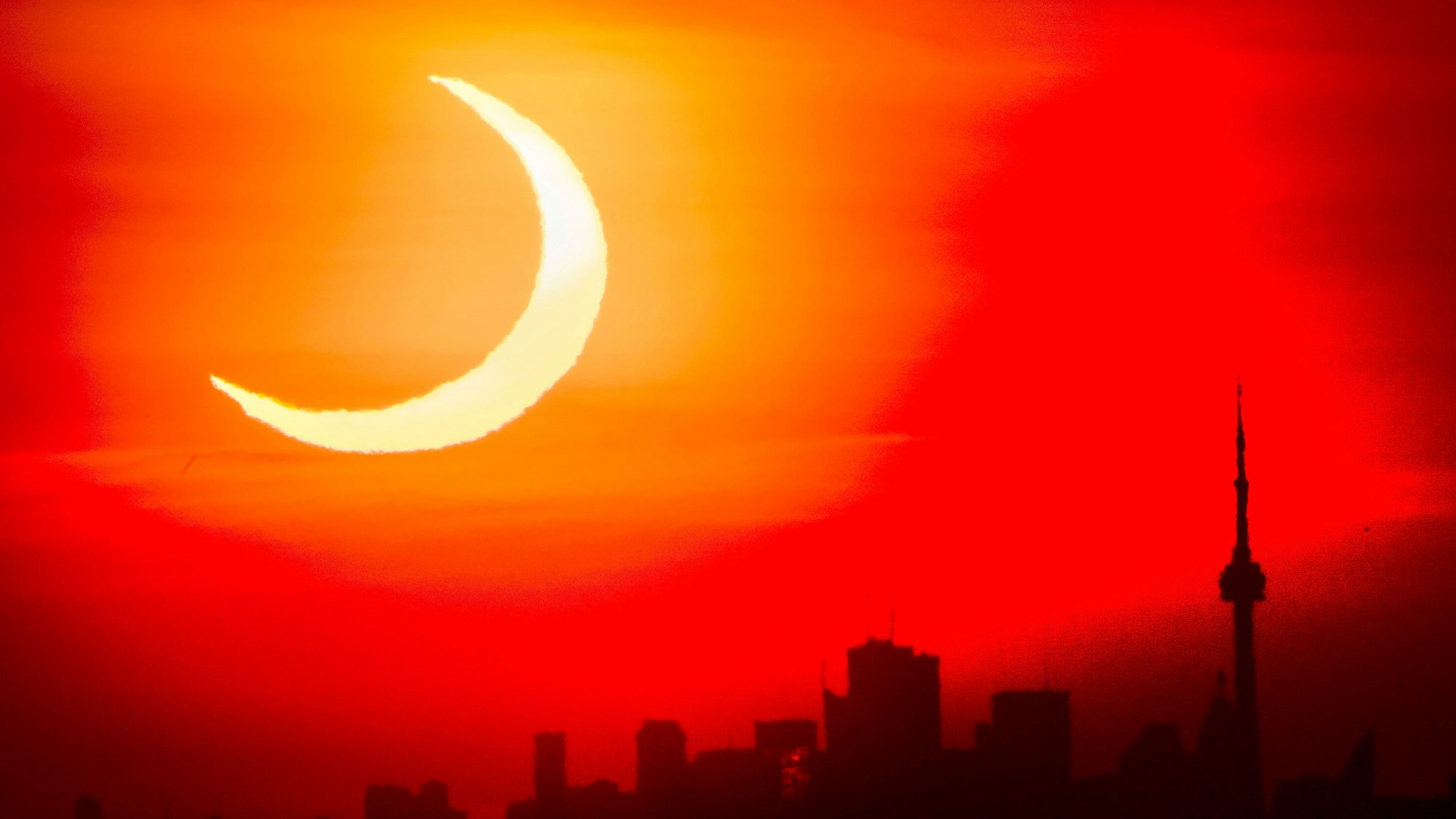 Eine Sonnenfinsternis mit der Skyline der kanadischen Stadt Toronto.