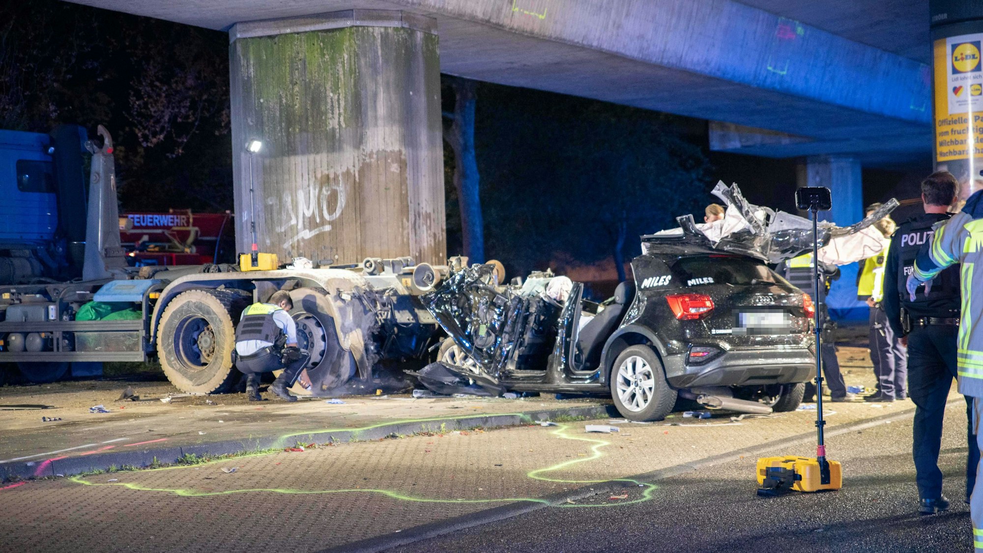 Ein Team der Polizei begutachtet den völlig zerstörten Audi nach einem schweren Unfall in Köln-Bilderstöckchen.