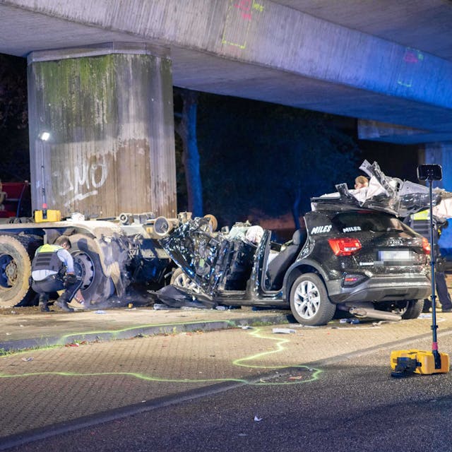 Ein Team der Polizei begutachtet den völlig zerstörten Audi nach einem schweren Unfall in Köln-Bilderstöckchen.