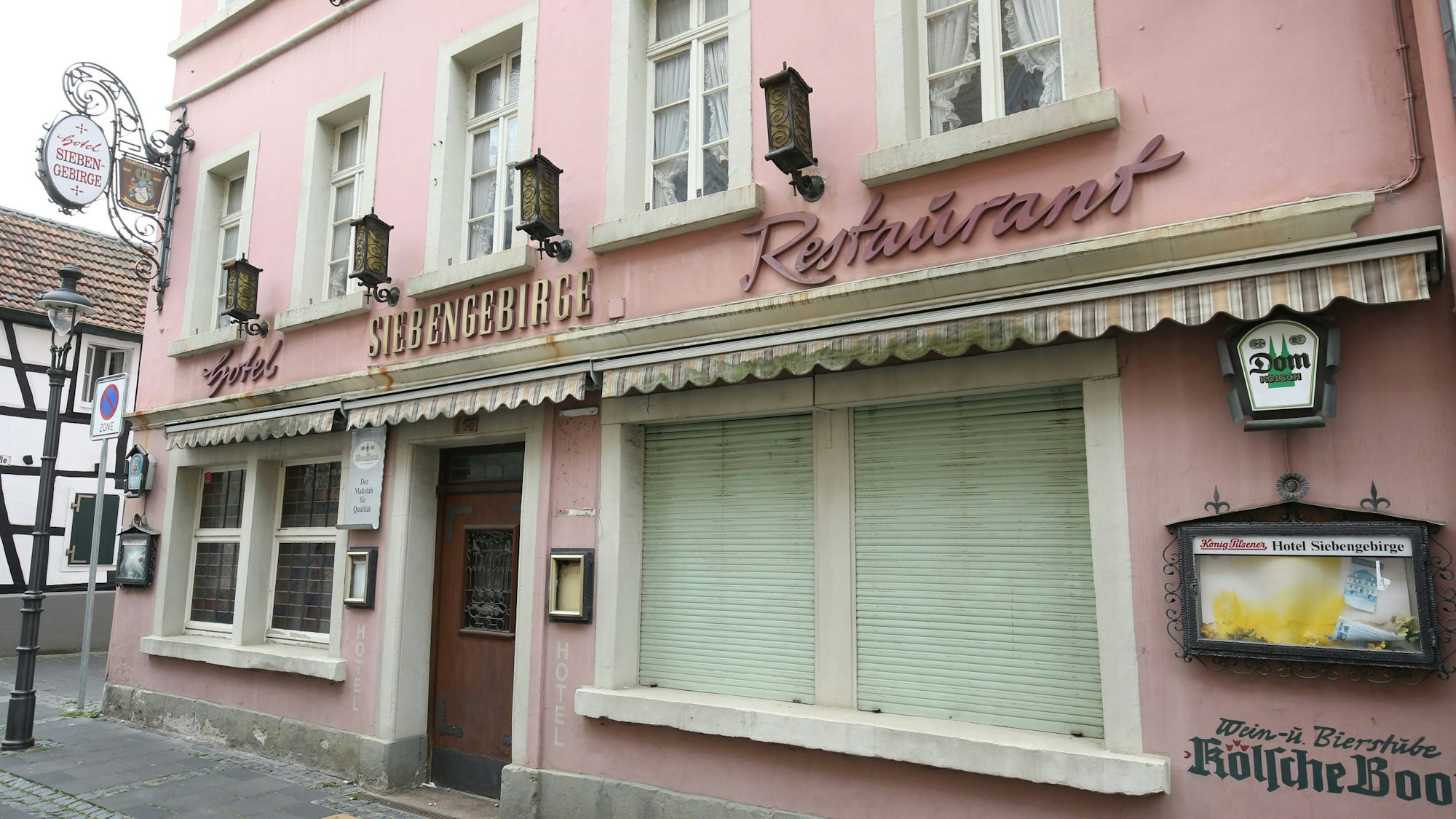 Ein ehemaliges Restaurant mit geschlossenen Rollläden an zwei Fenstern in der Fußgängerzone von Königswinter