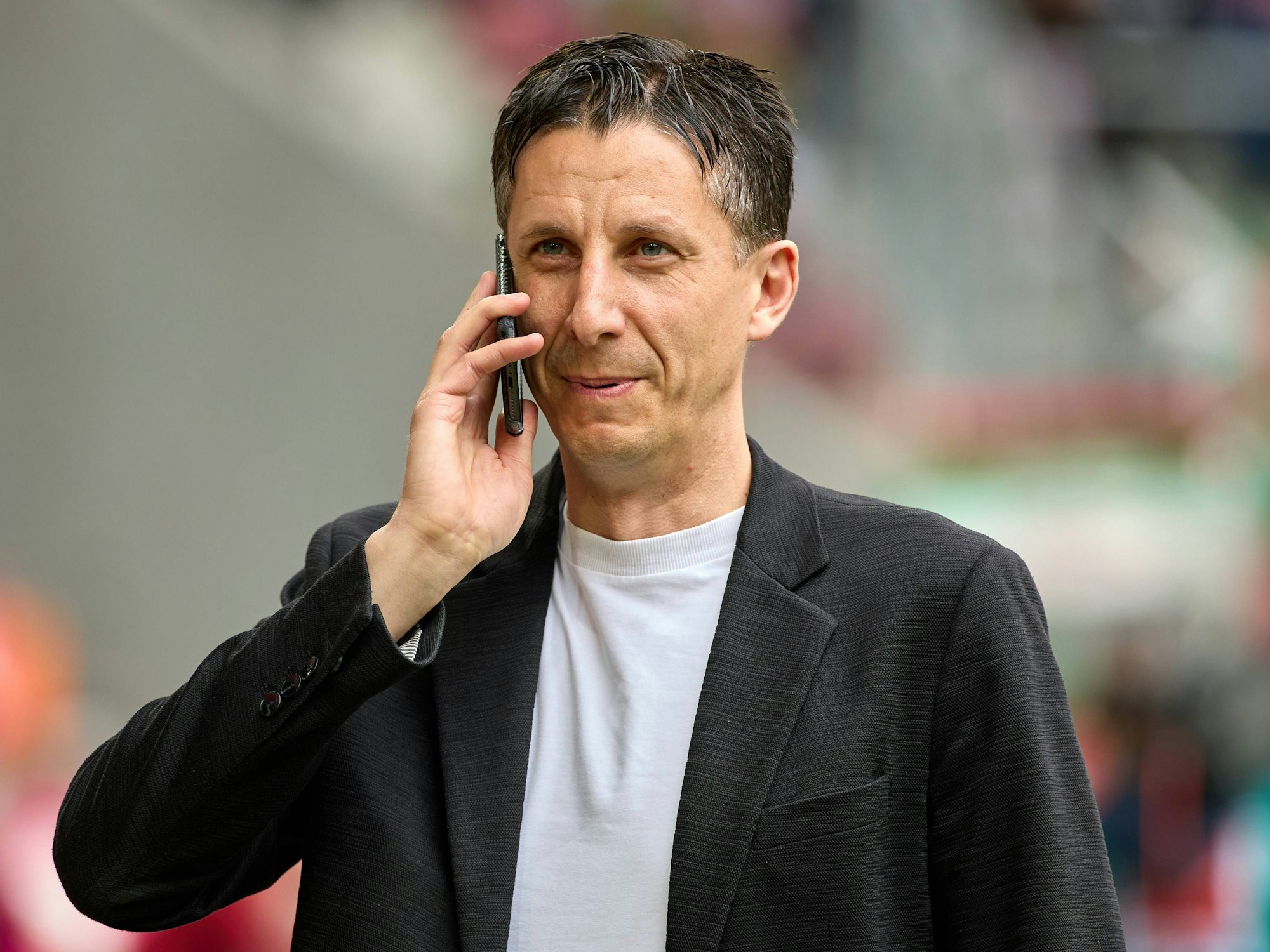 Christian Keller telefoniert im Stadion des 1. FC Köln.