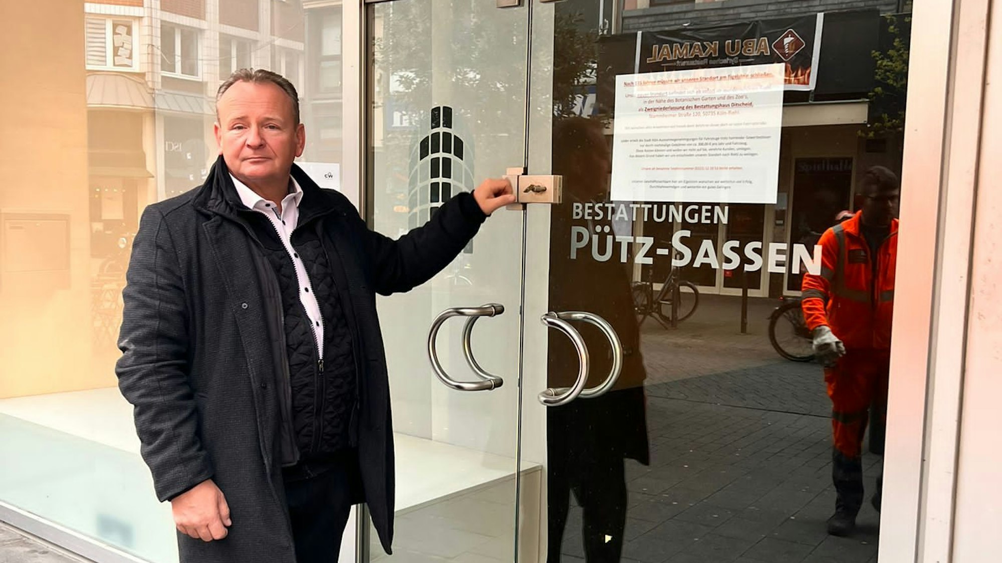 Frenk Ditscheid, Inhaber des Bestattungshauses Pütz-Sassen, steht vor seinem Geschäft. Foto von Bernd Schöneck
