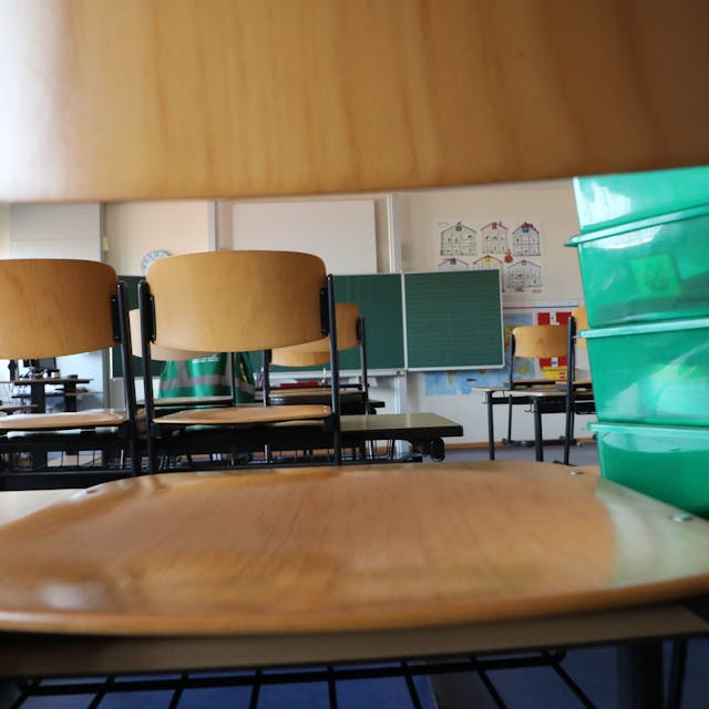 In einer Grundschule in Gera stehen die Stühle auf den Schultischen, der Klassenraum ist leer.&nbsp;