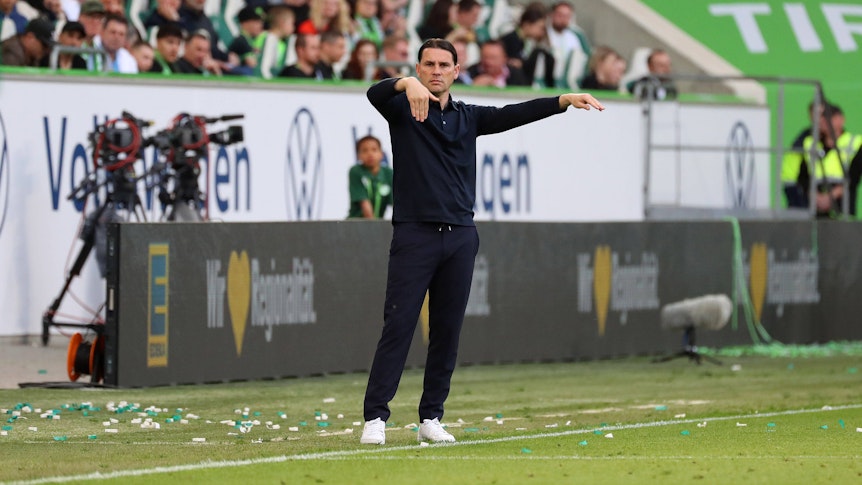 Trainer von Borussia Mönchengladbach mit Armbewegungen an der Seitenlinie.