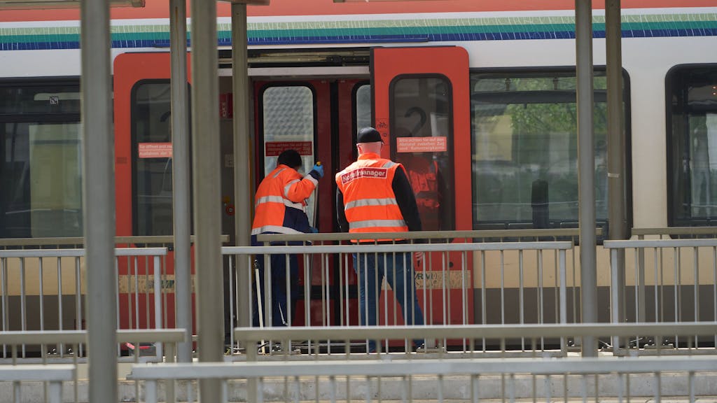 Ein Bahnbediensteter säubert am Bahnhof in Niederlahnstein einen Zug. Daneben steht ein Notfallmanager. In der Regionalbahn hat es einen Messerangriff auf einen Fahrgast gegeben, der schwer verletzt wurde.&nbsp;
