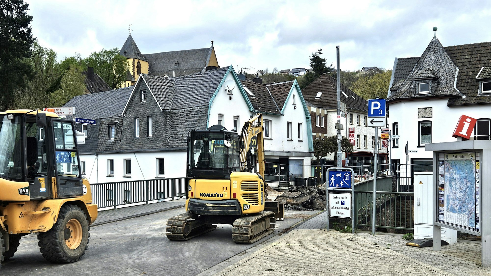 Ein Bagger und ein weiteres Baufahrzeug stehen an der Brücke in der Schleidener Innenstadt.