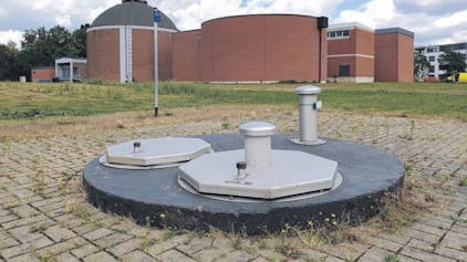 Das Foto zeigt einen abgedeckten Brunnenschacht vor den Gebäuden des Wasserwerks in Efferen.